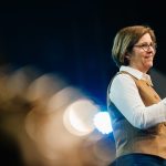 Woman speaker at Katoomba Easter Convention with microphone and stage lights.