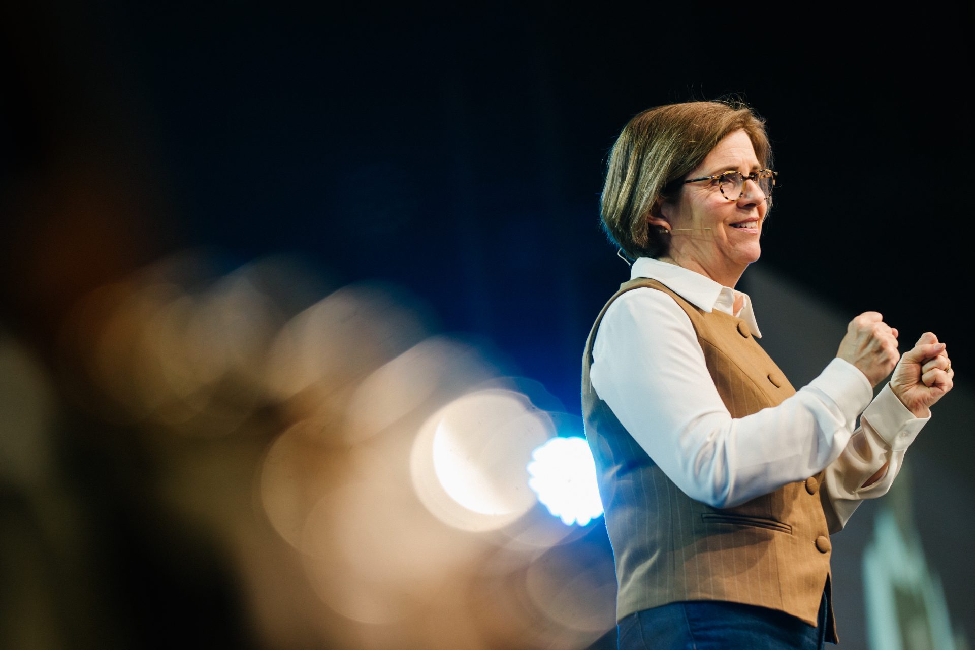 Woman speaker at Katoomba Easter Convention with microphone and stage lights.